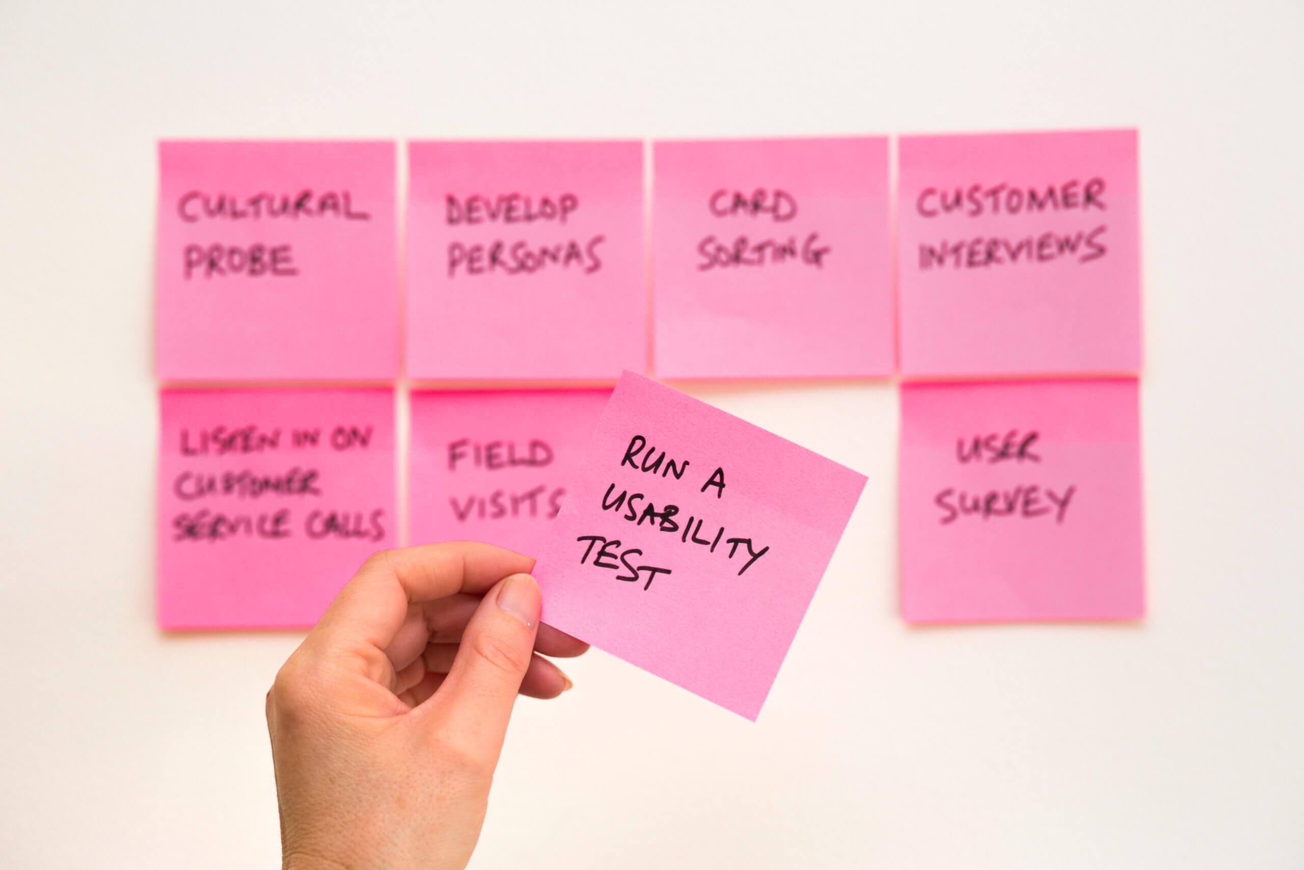 4 Things Every Product Manager Needs to Think About Before Development Business tasks on rows of pink post-its