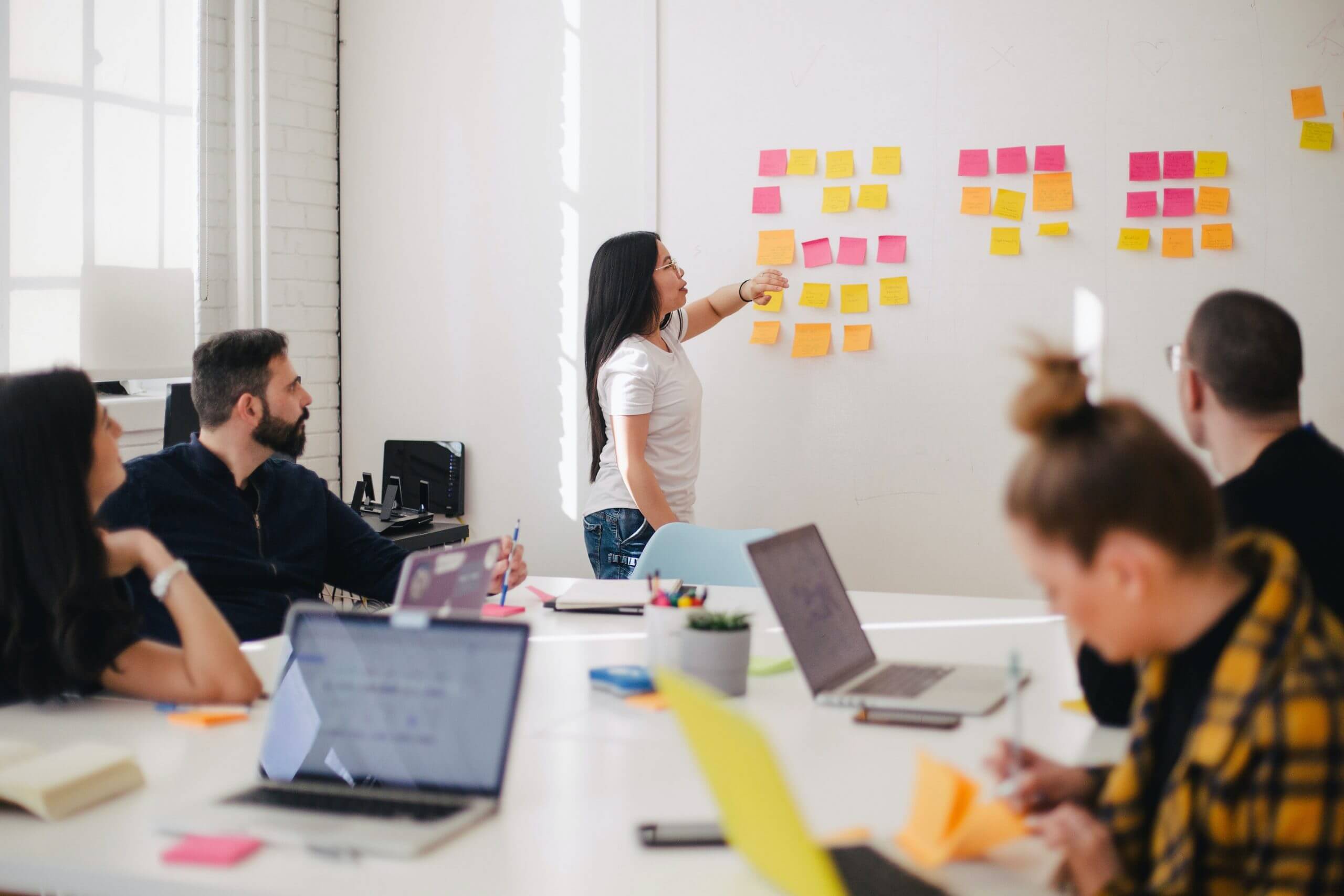build-customer-backed-logic-with-scrappy-research Employees with laptops having a meeting